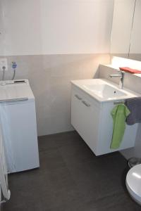 フィッツナウにあるFerienwohnung Mätzliの白いバスルーム(シンク、緑のタオル付)