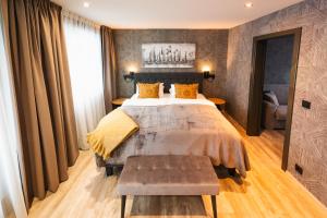 Un dormitorio con una cama grande y un banco. en Centrum Hotel, en Akureyri