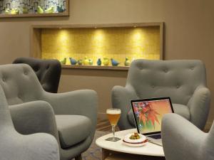 a room with two chairs and a table with a laptop at ibis Styles Chaumont Centre Gare in Chaumont
