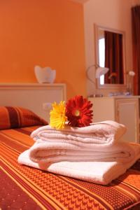 Ein Stapel Handtücher mit Blumen auf einem Bett in der Unterkunft Hotel Etrusco in Rio Marina