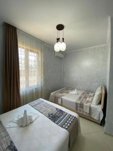 a hotel room with two beds and a window at Hotel Ergo in Batumi