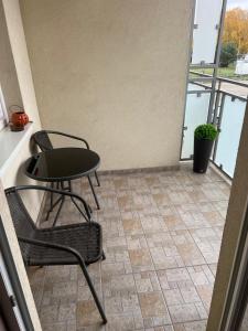 a table and chairs in a room with a balcony at Apartament Zacisze in Kalisz