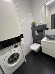 a bathroom with a washing machine and a sink at Apartament Zacisze in Kalisz