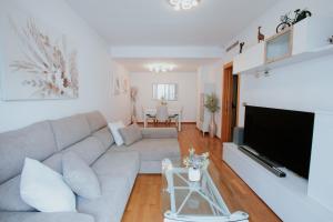 ein Wohnzimmer mit Couch und Flachbildfernseher in der Unterkunft Family & Friends Apartment with Pool in Torrent