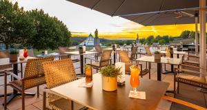a restaurant with tables and chairs and an umbrella at Victor's Residenz-Hotel Teistungenburg in Teistungen