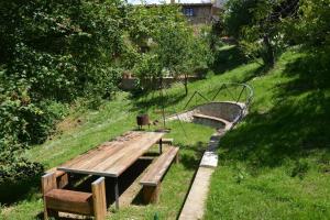 Un banco de madera sentado en el césped junto a un puente. en Monolocale, en Radicondoli