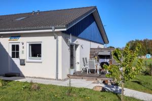 アルテフェーアにあるFerienhaus La Mer In Altefährの青屋根の小さな白い家