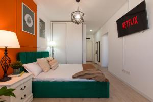 - une chambre avec un lit vert et des murs orange dans l'établissement Ivory Residence - Modern Minimalist Studio Apartment, à Bucarest