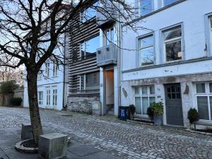 une rue pavée en face d'un bâtiment blanc dans l'établissement Bergen Centrum Modern Apartment, à Bergen