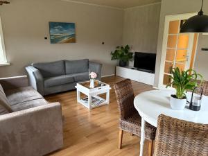 ein Wohnzimmer mit Sofa und Tisch in der Unterkunft Vakantiehuisje Wekerom in Wekerom