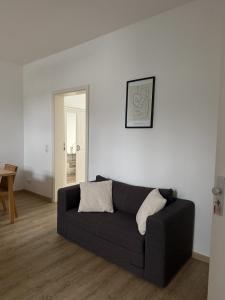 a living room with a black couch and a table at Wupper Apartments Vogel in Erbschlö