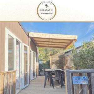 a wooden pergola on a deck with a table at EL Miya Sol Mobil Home à 200m de la Plage in Torreilles