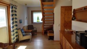 a living room with a spiral staircase in a house at Herich in Nieblum