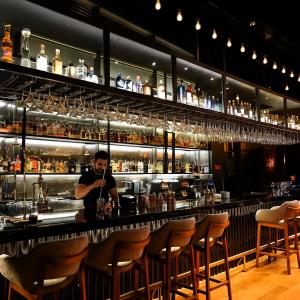 a man standing at a bar holding a drink at BK Hotel in Fethiye
