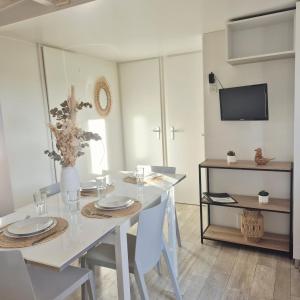 una sala da pranzo bianca con tavolo e sedie bianchi di EL Miya Sol Mobil Home à 200m de la Plage a Torreilles