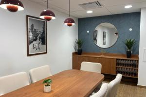 a dining room with a table and chairs and a mirror at Zenao Appart'hôtels Alfortville in Alfortville
