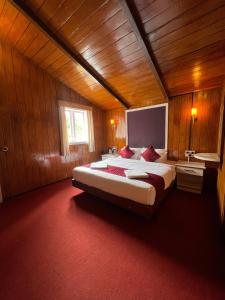 a bedroom with a large bed in a wooden room at The Groot in Ooty +22 photos