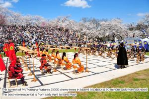 a group of people sitting in chairs in front of a crowd at Tendo Central Hotel in Tendo