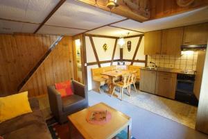 a living room and kitchen with a table and a couch at Fewo Mit Blick Auf Die Berge in Sedrun