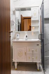 a bathroom with a white sink and a mirror at Garni Hotel Royal Crown in Subotica