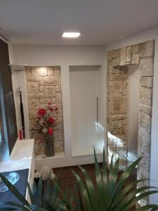 a room with a stone wall with a vase of flowers at Bergnest in Bad Gottleuba
