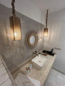 a bathroom with a sink and a mirror at Riad A l'Ombre du Palais in Oulad Akkou