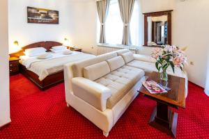 a living room with a couch and a bed at Garni Hotel Royal Crown in Subotica +148 photos