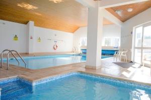 a swimming pool with a large swimming pool at Putsborough Cottage in Croyde