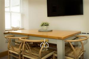 库勒Beachside Cottage - SJA Stays - Modern 3 Bed House的餐桌、两把椅子和一张桌子