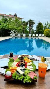 Un plato de comida en una mesa junto a una piscina. en Treekos Boutique Hotel Istanbul Airport, en Karaburun
