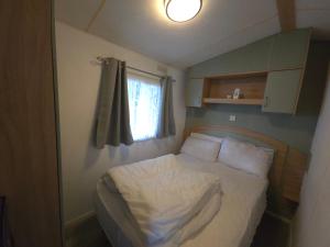 ein kleines Schlafzimmer mit einem Bett und einem Fenster in der Unterkunft The Retreat at Marine Holiday Park in Rhyl + 11 Fotos
