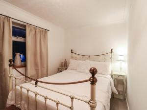 een slaapkamer met een bed en een raam bij Berkley Cottage in Coggeshall