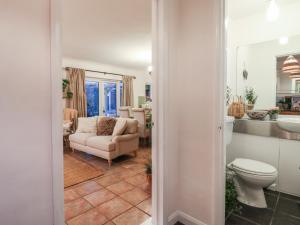 een woonkamer met een toilet en een bank bij Berkley Cottage in Coggeshall +36 foto's
