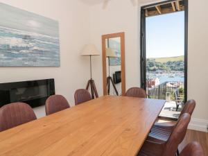 a dining room with a wooden table and chairs at Ty'r Ddraig in Dartmouth
