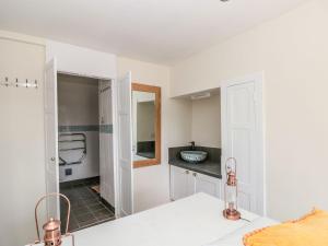 a white bathroom with a sink and a mirror at Ty'r Ddraig in Dartmouth +26 photos