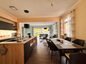 バート・ザクサにあるDer Fuchsbau - Ferienwohnung "Auszeit Harz" - 3 Hunde willkommen - eingezäunter Gartenのテーブルと椅子のあるキッチンとリビングルーム