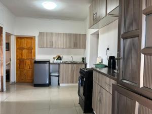 a kitchen with wooden cabinets and a black appliance at Cosy Corner in Pietermaritzburg
