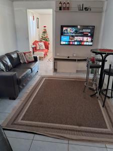 ein Wohnzimmer mit Sofa und Fernseher in der Unterkunft Pousada da Mari in São Gabriel