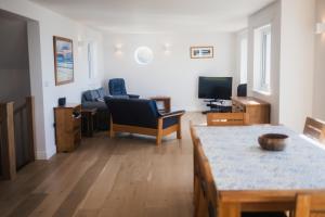 un soggiorno con un divano e una TV di Putsborough Cottage a Croyde