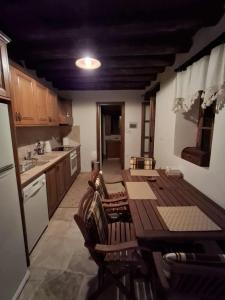 a kitchen with a wooden table and chairs in it at Lοfou-Queen in Lofou