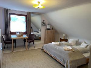 a bedroom with a bed and a table and a desk at Gästehaus Sandvoss in Titisee-Neustadt