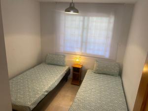 two beds in a small room with a window at Vistamar - Inalko in Alcossebre