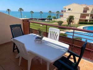 a white table and chairs on a balcony with a pool at Vistamar - Inalko in Alcossebre