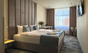 a bedroom with a large bed and a window at Oysters & Bubbles Gastro Rooms Rynek Square in Poznań