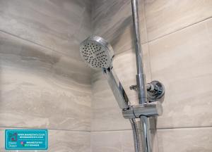 une douche avec pommeau de douche dans une salle de bain dans l'établissement Modern 3 Bedroom Home, 6 beds, Free Parking, 500MBS, Netflix, Near Coventry City Centre & Hospital, Contractors, Families, Apple Air Play, à Coventry 36 autres photos