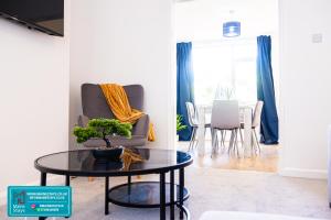 un salon avec une chaise et une table dans l'établissement Modern 3 Bedroom Home, 6 beds, Free Parking, 500MBS, Netflix, Near Coventry City Centre & Hospital, Contractors, Families, Apple Air Play, à Coventry
