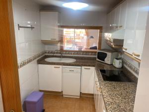 a small kitchen with a sink and a microwave at Vistamar - Inalko in Alcossebre