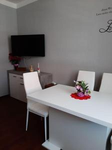 a white table with two white chairs and a television at Am Schlosspark in Ilmenau