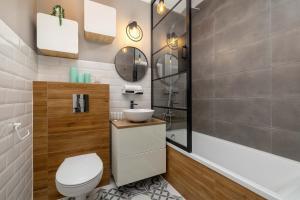 a bathroom with a toilet and a sink and a tub at Modern 2-Bedroom Apartment with Remote Workspace in Katowice by Noclegi Renters in Katowice