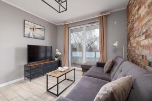 a living room with a couch and a television at Modern 2-Bedroom Apartment with Remote Workspace in Katowice by Noclegi Renters in Katowice +20 photos